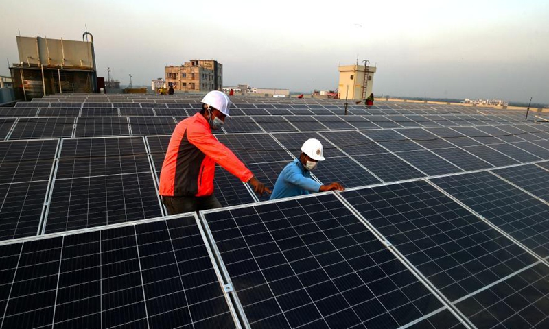 Supervisors monitor installation process of solar panels on factory