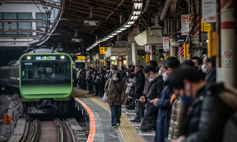 Commuters wear masks at a Tokyo train station while waiting on Tuesday. Japanese media said the country may expand its state of COVID-19 emergency to the western prefectures of Osaka, Kyoto and Hyogo on Wednesday. Photo: VCG