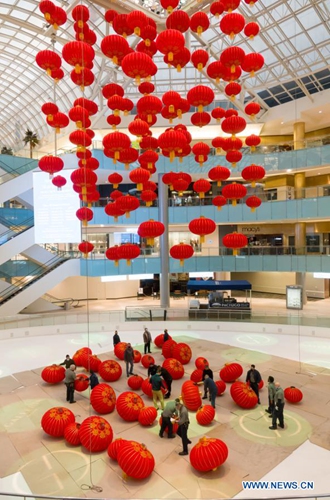 Staff members install red lanterns in Galleria Dallas shopping mall in ...