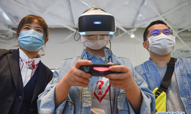 A consumer tries a gaming console during the Lunar New Year holiday at a duty-free shopping mall in Haikou, south China's Hainan Province, Feb. 14, 2021. (Xinhua/Pu Xiaoxu) 