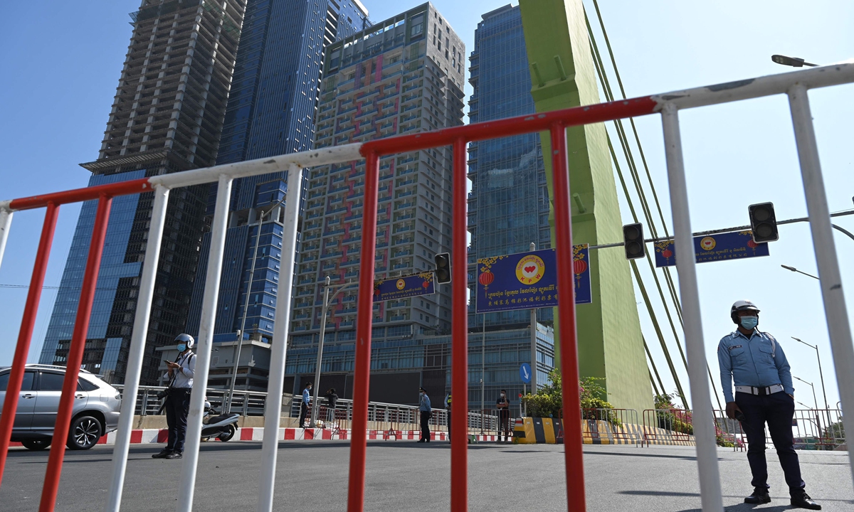 Cambodian police stand guard as they lock down a bridge to the Koh Pich district in capital Phnom Penh on Saturday, after authorities found 32 local cases of COVID-19 infections.  Photo: VCG