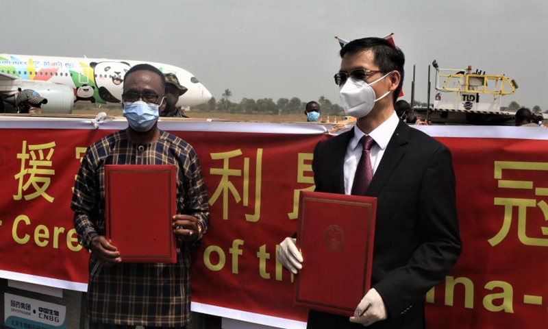 Chinese Ambassador to Sierra Leone Hu Zhangliang (R) attends a handover ceremony of the Sinopharm COVID-19 vaccine donated by China at an airport in Freetown, Sierra Leone, on Feb. 25, 2021. Sierra Leone on Thursday received a consignment of 200,000 doses of China's Sinopharm COVID-19 vaccine donated by China to support the country's vaccination campaign. (Photo by Abu/Xinhua)