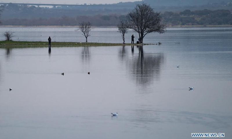 People fish at Manzanares el Real Reservoir, Spain, on Feb. 28, 2021.(Photo: Xinhua)