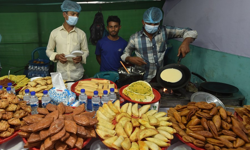 Vendors make handmade cakes known as Pitha at a stall during a festival in Dhaka, Bangladesh on Feb. 27, 2021.(Photo: Xinhua)