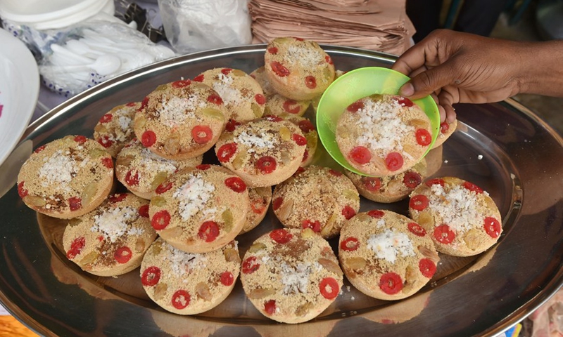 A vendor arranges handmade cakes known as Pitha at a stall during a festival in Dhaka, Bangladesh on Feb. 27, 2021. (Photo: Xinhua)