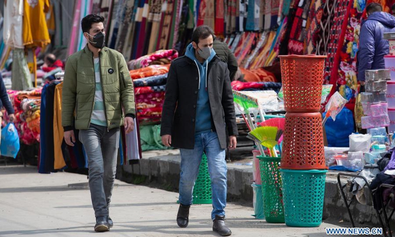 People wearing face masks walk at a market in Srinagar city, the summer capital of Indian-controlled Kashmir, Feb. 28, 2021. (Photo: Xinhua)