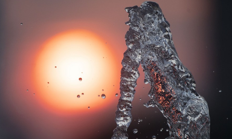 Light from a setting sun passes through a water fountain in Singapore Sports Hub on Feb. 28, 2021.(Photo: Xinhua)