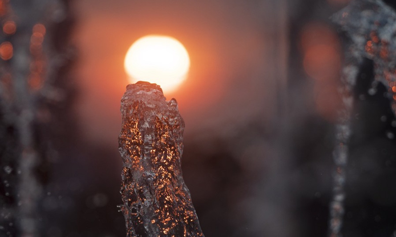 Light from a setting sun passes through a water fountain in Singapore Sports Hub on Feb. 28, 2021.(Photo: Xinhua)