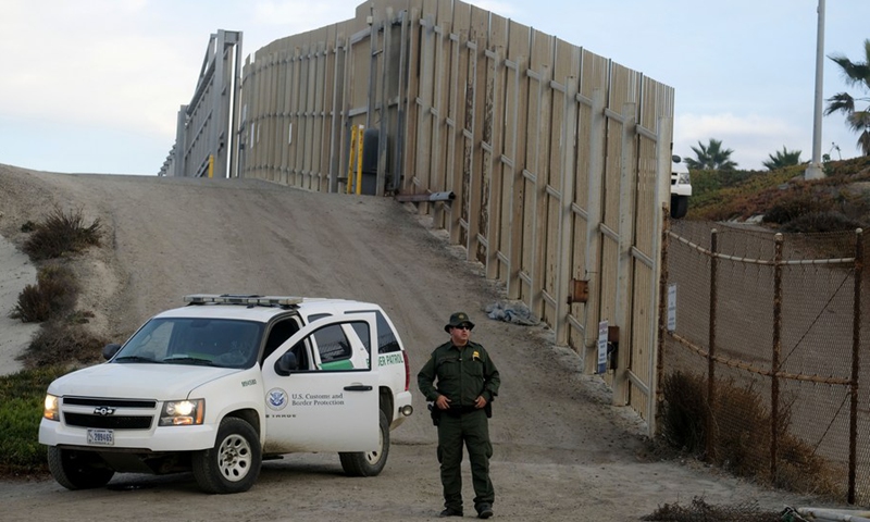 A U.S. Border Patrol agent stands in front of the border fence that divides the United States and Mexico in San Diego, California, the United States, Nov. 17, 2018.(Photo: Xinhua)