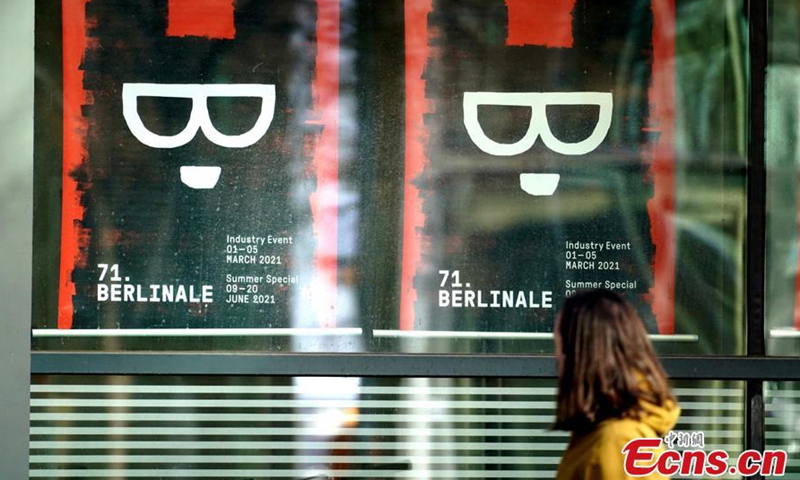 A woman passes by a poster for the 71st Berlin International Film Festival in Berlin, Germany.Photo:China News Service