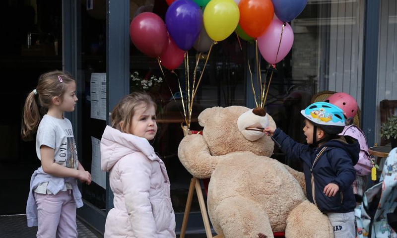 Children play with a giant teddy bear outside a restaurant in Paris, France, March 3, 2021. Giant teddy bears are seen at a restaurant which offers take away services in Paris. Restaurants, bars and cafes haved been all forced to shut down when the country entered into its second lockdown on Oct. 30, 2020.Photo:Xinhua