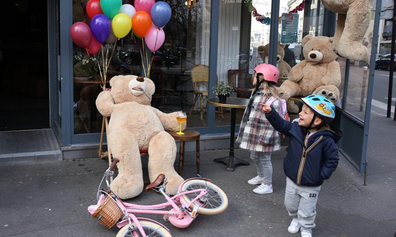 Children play with a giant teddy bear outside a restaurant in Paris, France, March 3, 2021. Giant teddy bears are seen at a restaurant which offers take away services in Paris. Restaurants, bars and cafes haved been all forced to shut down when the country entered into its second lockdown on Oct. 30, 2020.Photo:Xinhua