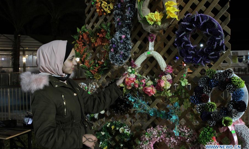 A Palestinian woman arranges her handicrafts at a handicraft exhibition in Gaza City, on March 6, 2021.(Photo: Xinhua)