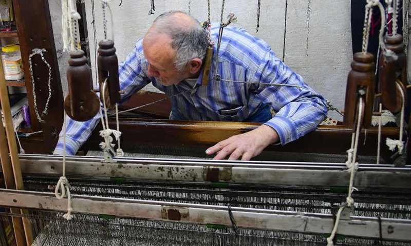 Munir Masdi weaves textiles in the traditional way at an old loom in the capital Damascus on March 7, 2021. Masdi is one of the few remaining craftsmen who still work at old looms, a profession that might soon vanish in Syria.Photo:Xinhua