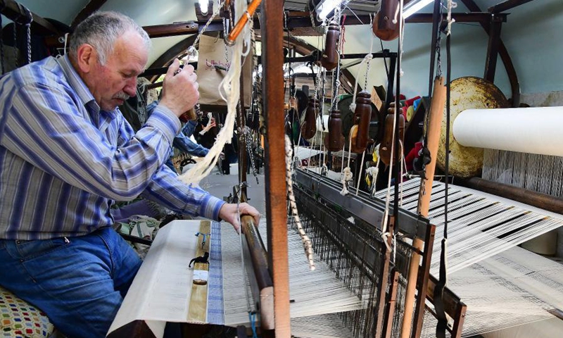 Munir Masdi weaves textiles in the traditional way at an old loom in the capital Damascus on March 7, 2021. Masdi is one of the few remaining craftsmen who still work at old looms, a profession that might soon vanish in Syria.Photo:Xinhua