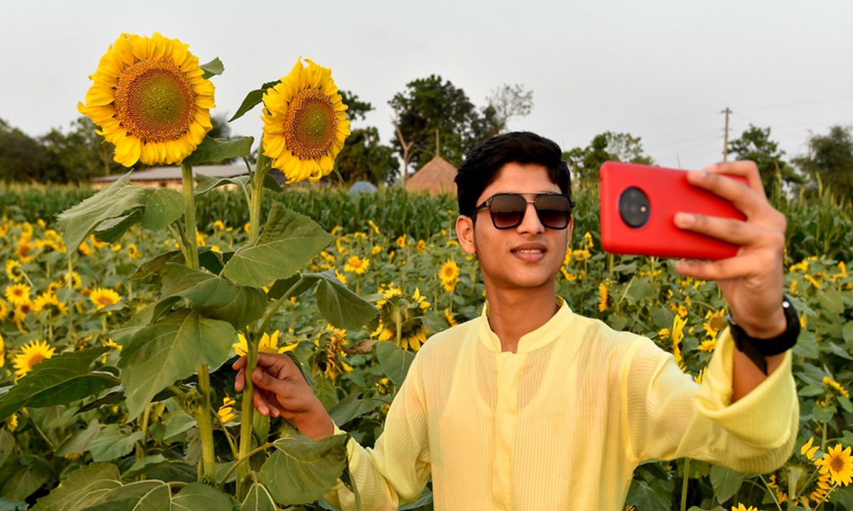 A man takes a selfie at a sunflower field in Brahmanbaria district, Bangladesh, on March 6, 2021. (Xinhua)