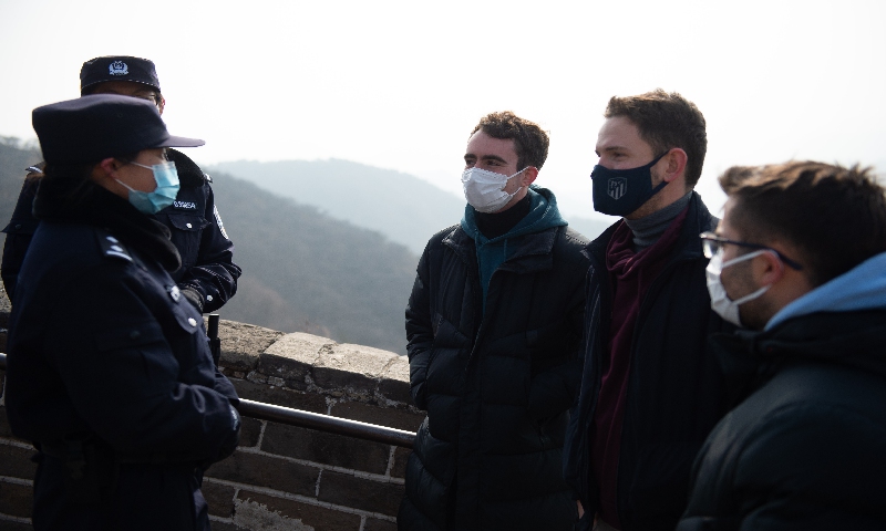 Liu Xuwen (L, front) and Zhang Anqi (L, behind), members of the female police force of Badaling Police Station, help foreign tourists on the Badaling Great Wall in Beijing, capital of China, March 7, 2021.(Photo: Xinhua)