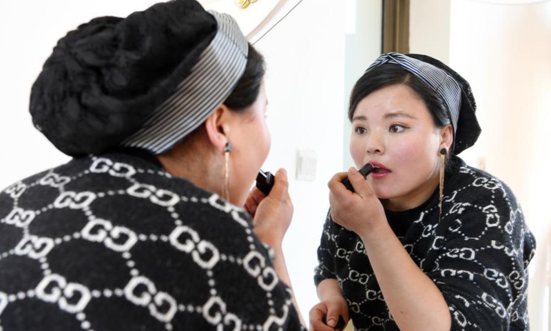 Ma Linhong puts on makeup at home in Nanyangwa Village of Dongxiang Autonomous County of Linxia Hui Autonomous Prefecture, northwest China's Gansu Province, March 4, 2021.Photo:Xinhua