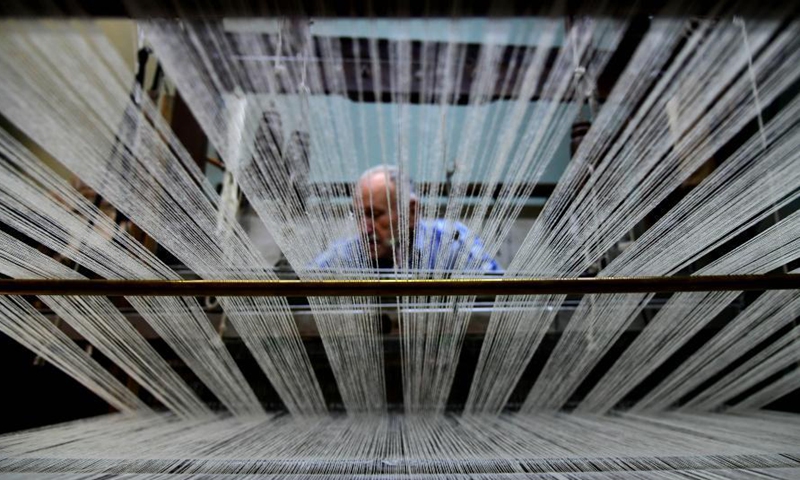 Munir Masdi weaves textiles in the traditional way at an old loom in the capital Damascus on March 7, 2021. Masdi is one of the few remaining craftsmen who still work at old looms, a profession that might soon vanish in Syria.Photo:Xinhua