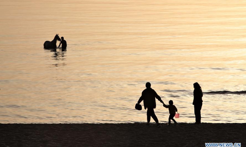 People are seen at a seaside during sunset in Beirut, Lebanon, March 10, 2021.Photo:Xinhua