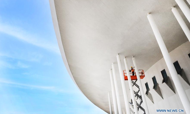 A worker uses a lift to paint the wall of a pavilion of the China Flower Expo in east China's Shanghai, March 10, 2021. The 10th China Flower Expo will take place from May 21 to July 2 in Shanghai's Chongming District. Preparation for the expo is now in its final stage.Photo:Xinhua