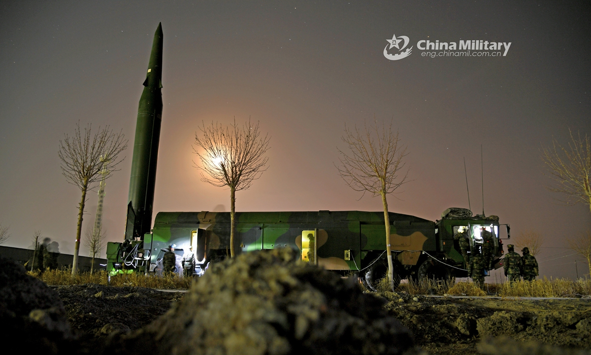 Soldiers assigned to a brigade under the PLA Rocket Force erect a ballistic missile launcher into position on the launching truck at night during a recent realistic training exercise.Photo:China Military
