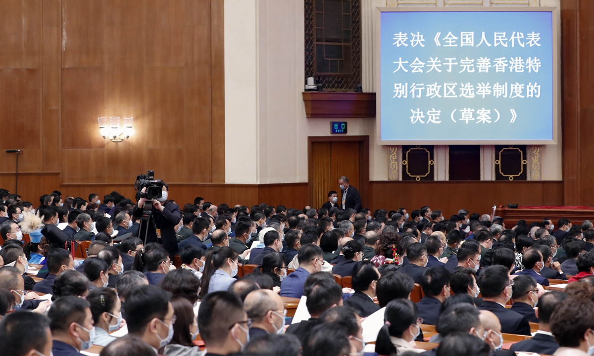 The National People's Congress (NPC), China's top legislature, adopts a decision to improve the electoral system of the Hong Kong Special Administrative Region on Thursday.The decision was passed by an overwhelming majority vote at the fourth session of the 13th NPC in Beijing. 
Photo: cnsphoto