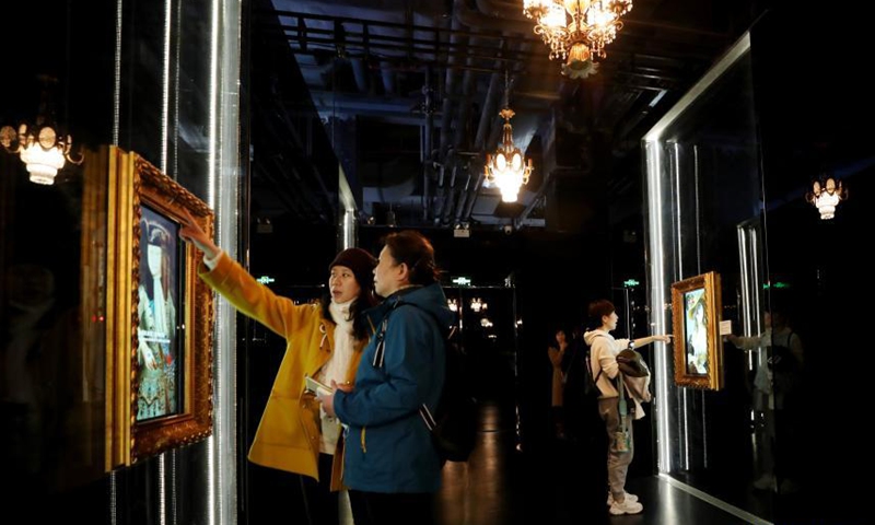 Visitors experience an interactive game of changing faces for a painting of the Versailles palace during an exhibition in Shanghai, east China, March 12, 2021. A China itinerant exhibition of Versailles palace is held at Xintiandi commercial complex in Shanghai, during which digital technologies and interactive activities offer people the unique experience of visiting the palace.    Photo:Xinhua