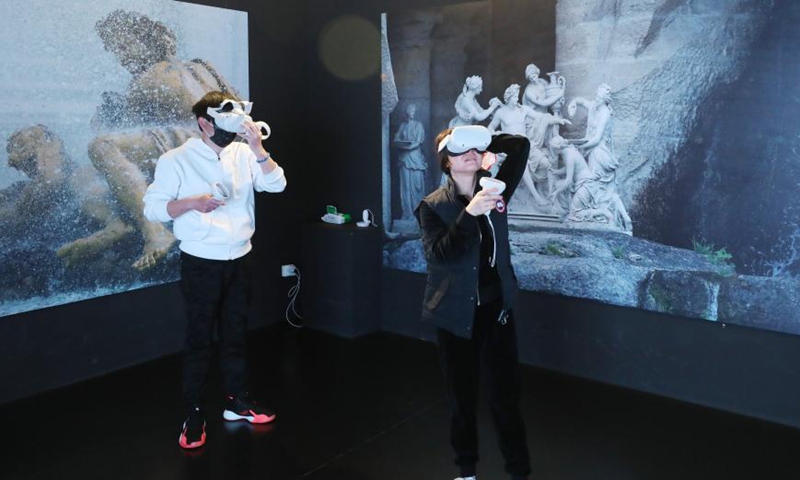 People use VR glasses to visit the Versailles palace during an exhibition in Shanghai, east China, March 12, 2021. A China itinerant exhibition of Versailles palace is held at Xintiandi commercial complex in Shanghai, during which digital technologies and interactive activities offer people the unique experience of visiting the palace.   Photo:Xinhua