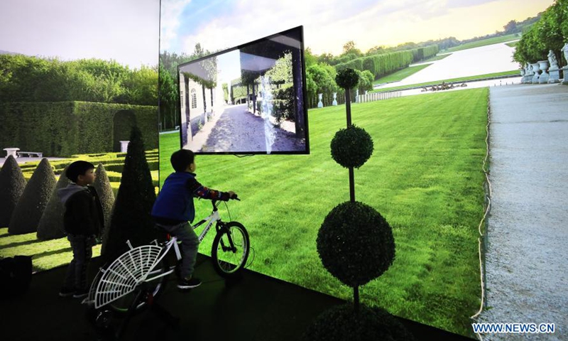 A child experiences a game of riding in the Versailles palace during an exhibition in Shanghai, east China, March 12, 2021. A China itinerant exhibition of Versailles palace is held at Xintiandi commercial complex in Shanghai, during which digital technologies and interactive activities offer people the unique experience of visiting the palace.   Photo:Xinhua