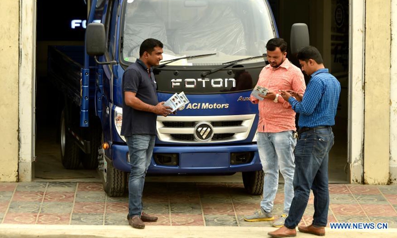 Customers learn about Foton commercial vehicle at a sales center in Munshiganj, Bangladesh on March 9, 2021. Foton vehicles are gaining popularity in Bangladesh, pickups in particular. Selling of commercial vehicles is on the rise in Bangladesh with the upgrading of roads in the country's rural areas. TO GO WITHFoton commercial vehicles gain popularity in Bangladesh  Photo: Xinhua