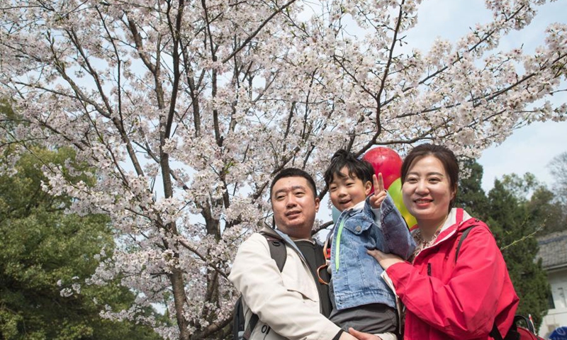 A medical worker from Dandong of Liaoning Province poses for photo with her family at Wuhan University in Wuhan, central China's Hubei Province, March 13, 2021. Wuhan University, one of the best places in the city to feast the eyes of cherry blossom admirers, announced it would offer free exclusive tours and performances for medical workers across China who had assisted Wuhan with the fight against the epidemic in 2020 and their relatives from Saturday to Sunday.(Photo: Xinhua)