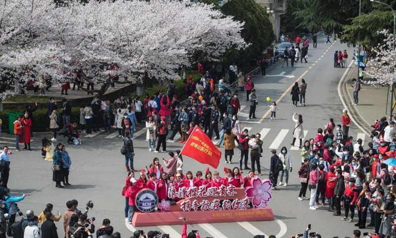 Medical workers from Liaoning Province pose for photo at Wuhan University in Wuhan, central China's Hubei Province, March 13, 2021. Wuhan University, one of the best places in the city to feast the eyes of cherry blossom admirers, announced it would offer free exclusive tours and performances for medical workers across China who had assisted Wuhan with the fight against the epidemic in 2020 and their relatives from Saturday to Sunday.(Photo: Xinhua)