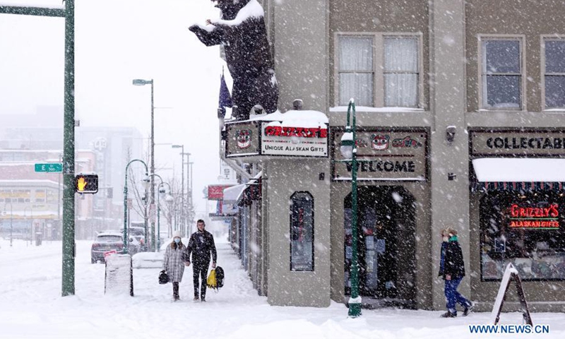 People walk in snow in Anchorage, Alaska, the United States, on March 15, 2021. A heavy snowfall hits Anchorage on Monday.Photo:Xinhua