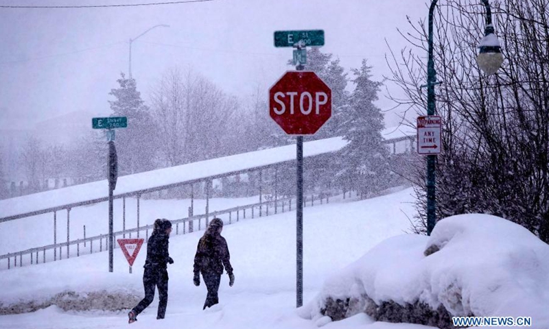 People walk in snow in Anchorage, Alaska, the United States, on March 15, 2021. A heavy snowfall hits Anchorage on Monday.Photo:Xinhua