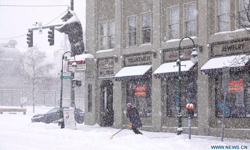 A man cleans up snow in Anchorage, Alaska, the United States, on March 15, 2021. A heavy snowfall hits Anchorage on Monday.Photo:Xinhua