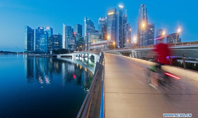 A cyclist rides up the Jubilee Bridge before sunrise in Singapore, on March 16, 2021.(Photo: Xinhua)