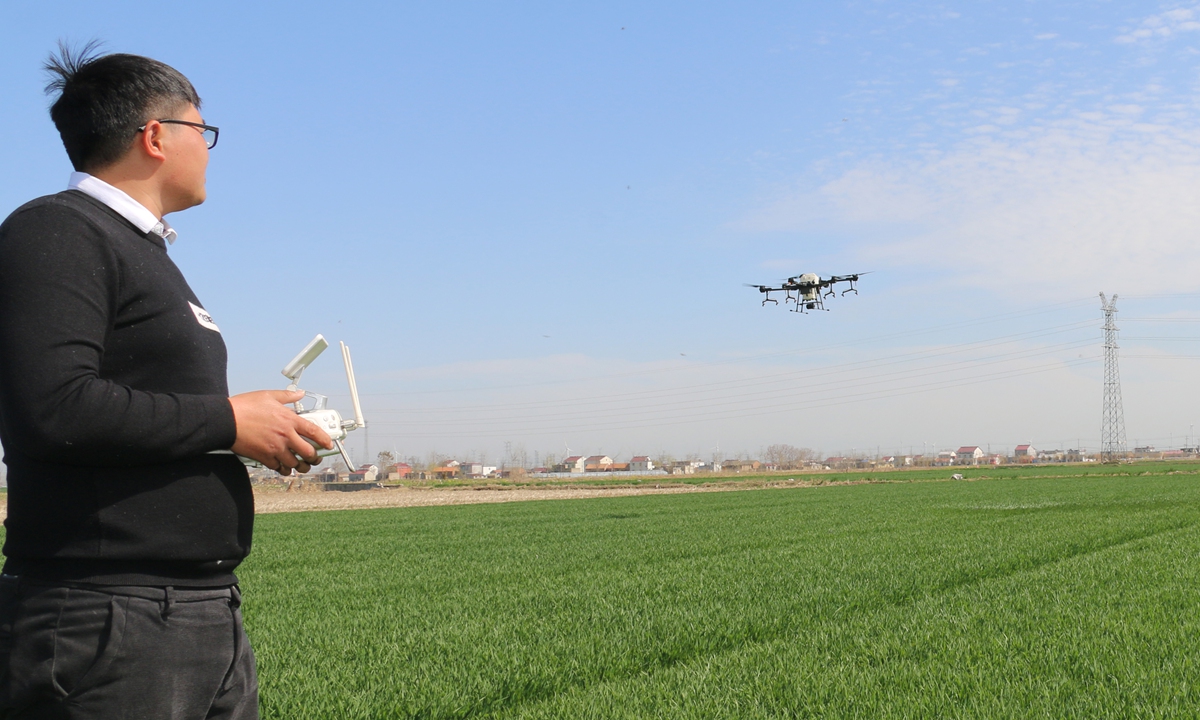 An employee operates an agricultural spraying drone in a county in Lianyungang, East China's Jiangsu Province on Thursday. It's a crucial period for spring plowing on wheat farms, and local agricultural and rural departments have actively organized farmers for the farming season. Photo: cnsphoto