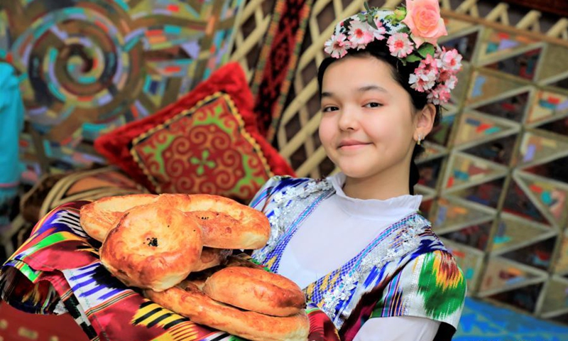 A girl shows traditional food during celebrations of Nauryz festival in Nur Sultan, Kazakhstan, March 19, 2021.(Photo: Xinhua)