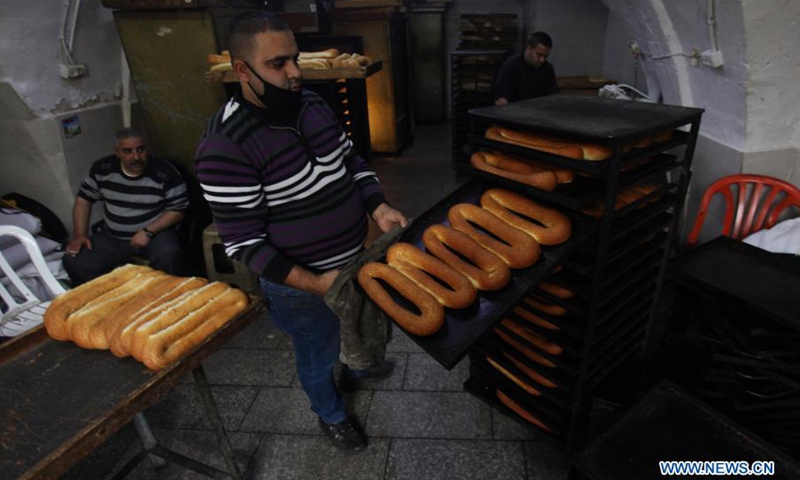 A Palestinian baker works at an old bakery to prepare sesame bread in the West Bank city of Nablus, March 22, 2021.(Photo: Xinhua)