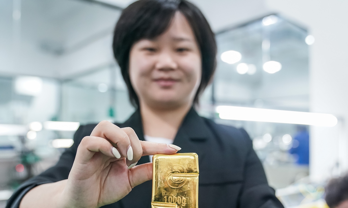 An employee shows a golden bar in a gold and jewel industrial park in Hezhou, South China's Guangxi Zhuang Autonomous Region on Thursday. The park is an important destination for industries transferring from the Guangdong-Hong Kong-Macao Greater Bay Area, and it has attracted 41 gold firms. Photo: cnsphoto