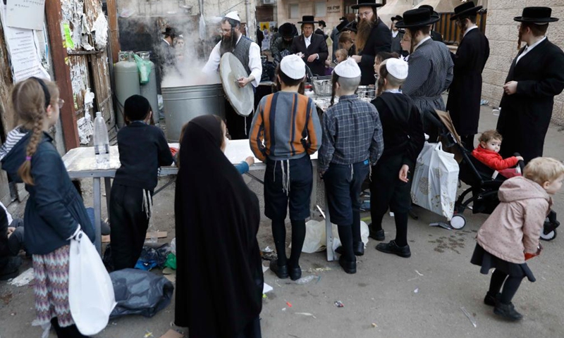 Ultra-Orthodox Jews dip their cookware in boiling water to remove remains of leaven during the final preparations before the start of the Jewish Passover holiday in Jerusalem on March 24, 2021.Photo:Xinhua