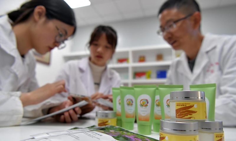 Fu Donghui (R) discusses with his students on the development of new products of cole flowers at Jiangxi Agricultural University in Nanchang, east China's Jiangxi Province, March 24, 2021.  Photo: Xinhua