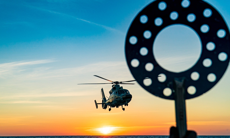 A ship-borne helicopter attached to a naval flotilla under the PLA Southern Theater Command cooperates with a warship to conduct anti-submarine task during a combined arms training exercise. The flotilla under training has traveled more than 8,000 nautical miles in over 30 days, conducting dozes of exercise items including air and missile defense, anti-terrorism and anti-piracy operation, and joint search and rescue.  Photo: China Military Online