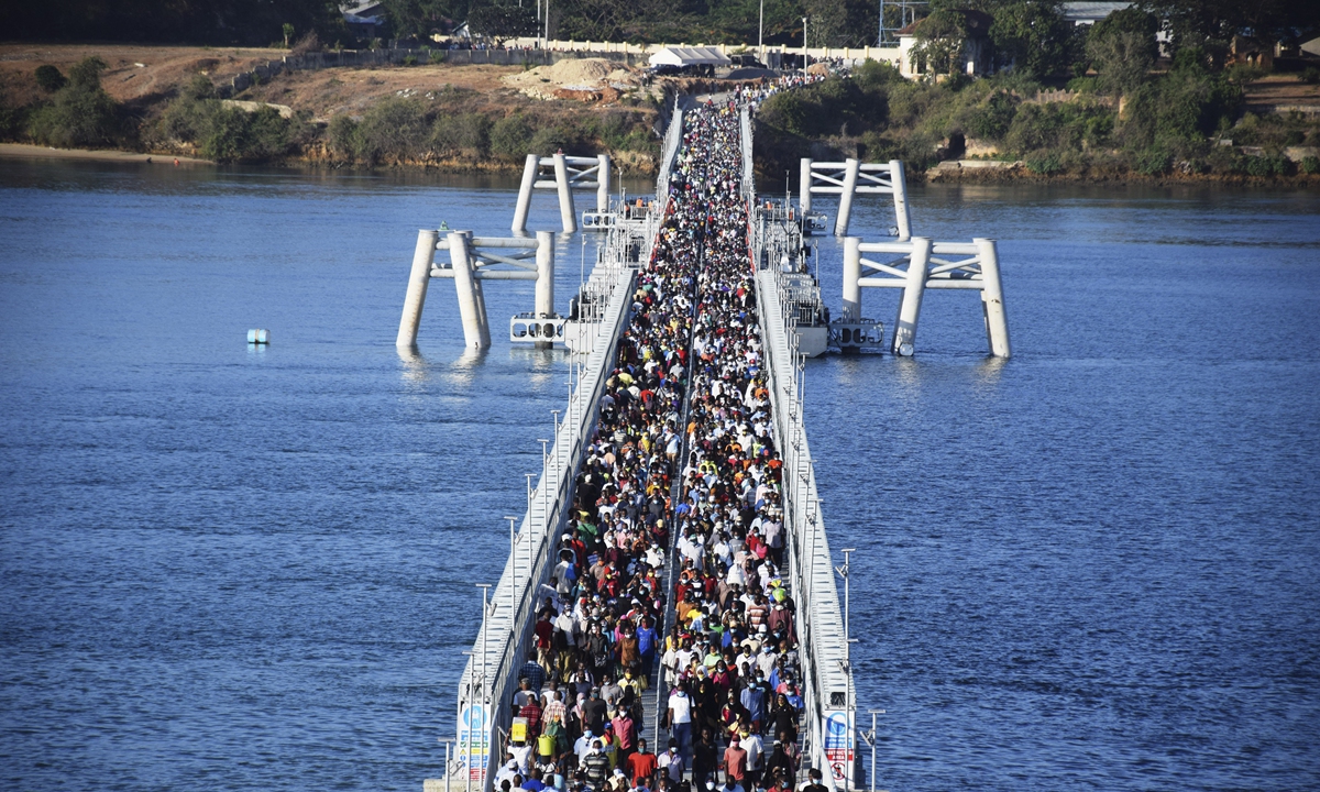 Hundreds of Kenyans cross a recently constructed floating foot bridge from Likoni mainland to Mombasa Island on Wednesday. More than 300,000 people now have to use the floating foot bridge after their traditional route - waterway via Likoni Ferry channel - was suspended for COVID-19 reasons.