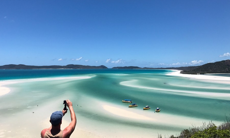 A tourist takes photos of Whitehaven Beach in the Whitsunday Islands, part of the Great Barrier Reef, Australia, on Feb. 10, 2018.(Photo: Xinhua)