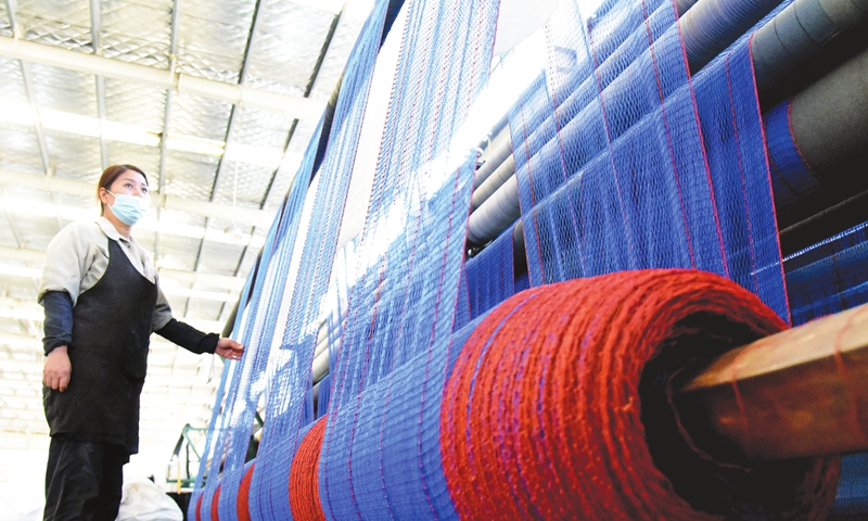 A woman works at a netting gear assembly line in the Haizhou Economic Development Zone in Lianyungang, East China's Jiangsu Province on Thursday. Netting gear manufacturers in the zone have become busy in recent days, with assembly workers ramping up production of varied nets for farming, crab harvesting, and badminton, among other purposes. The nets will be shipped to more than 20 countries and regions.  Photo: cnsphoto