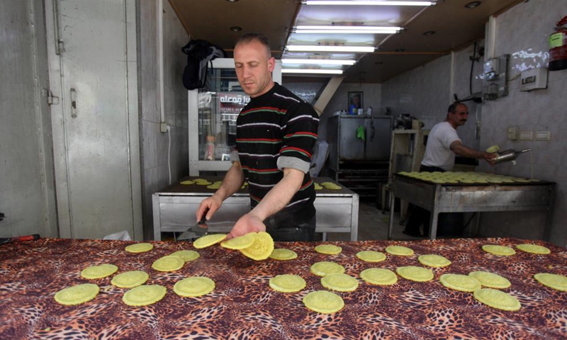 A Palestinian vendor makes traditional sweets known as Qatayef on the third day of the holy month of Ramadan at a local market in the West Bank city of Nablus, April 15, 2021.Photo:Xinhua