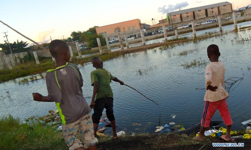 Paul Mkandawire (R) and his friends fish at a popular dam in Misisi compound, a slum in Zambia's capital Lusaka on April 12, 2021.(Photo: Xinhua)