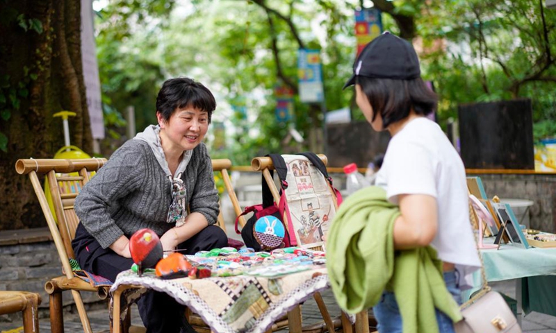 A vendor sells her products to a tourist in the Beicang Cultural & Creative Quarter, southwest China's Chongqing, April 22, 2021.Photo:Xinhua